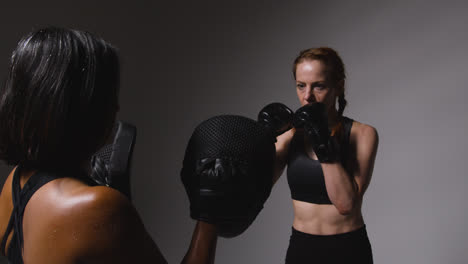 Studioaufnahme-Von-Zwei-Reifen-Frauen-In-Fitnesskleidung,-Die-Gemeinsam-Boxen-Und-Sparring-Trainieren-2